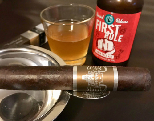 CAO Flathead cigar with distinctive band resting in ashtray beside craft beer glass and bottle